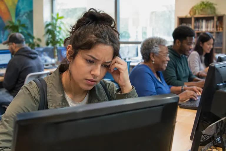 People using laptops and printed health materials in a community room